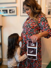A woman holds an ultrasound picture, symbolizing anticipation and care, aligned with WeNatal's prenatal focus.